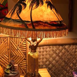 tiki lamp — warm glow, bamboo walls — photo by Din Tanovic, Stockholm