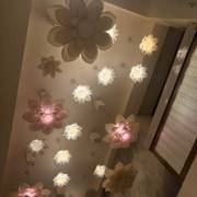 ceiling in bloom — ivory petals and soft pink light overhead.