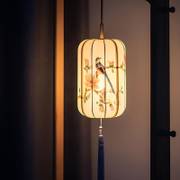 bird lantern — painted feathers, warm light, a dark tassel.