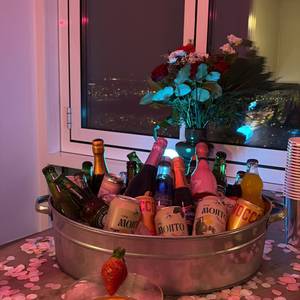 the set-up · pink confetti everywhere — Din Tanovic the set-up · pink confetti everywhere — drinks bucket by the window, city lights — photo by Din Tanovic, Stockholm